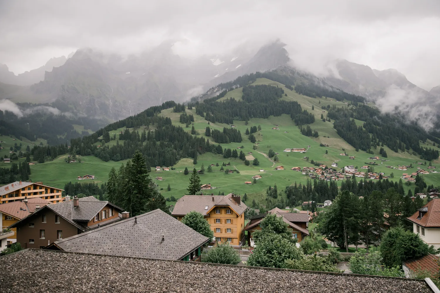 View at The Cambrian Adelboden with misty mountain views, curated by ROOXI STUDIO.