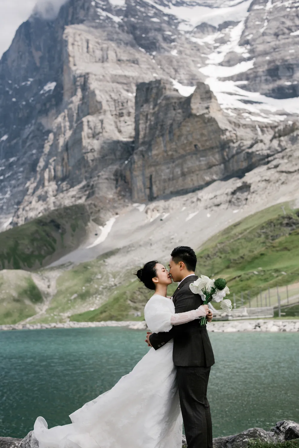 Intimate pre-wedding moments at Kleine Scheidegg with the fresh green landscapes of **June** in the Swiss Alps.