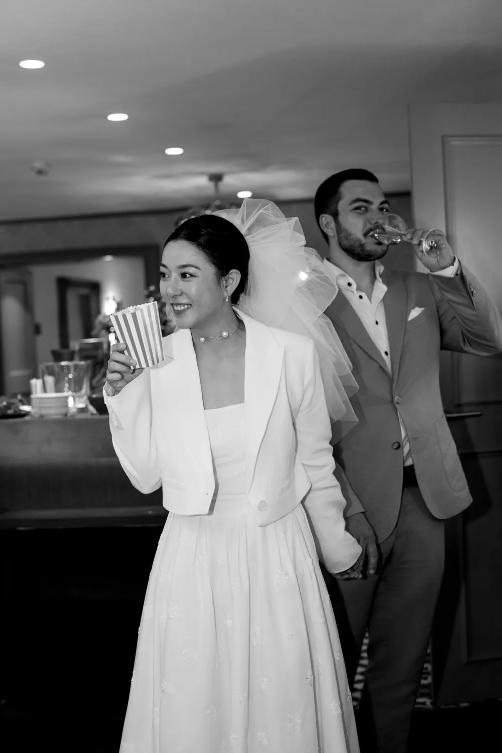 Candid **wedding photoshoot** of a couple enjoying popcorn at their indoor Apero in a Swiss castle.