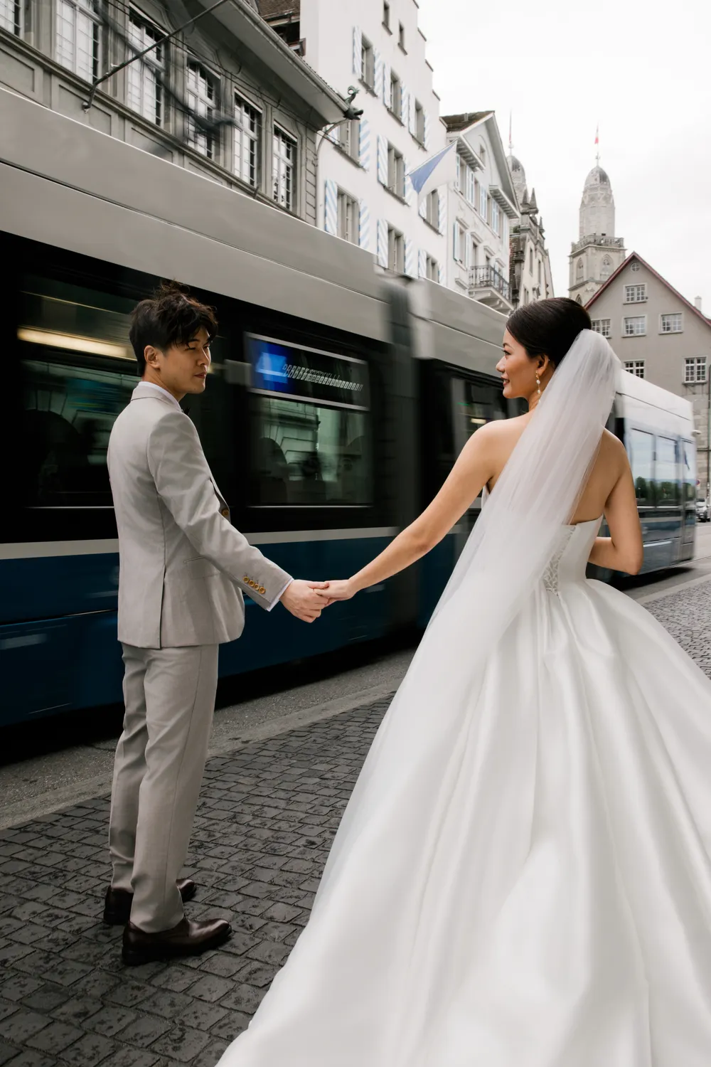 Intimate couple embrace in the sun-dappled cobbled streets of **Limmat, Zurich**.
