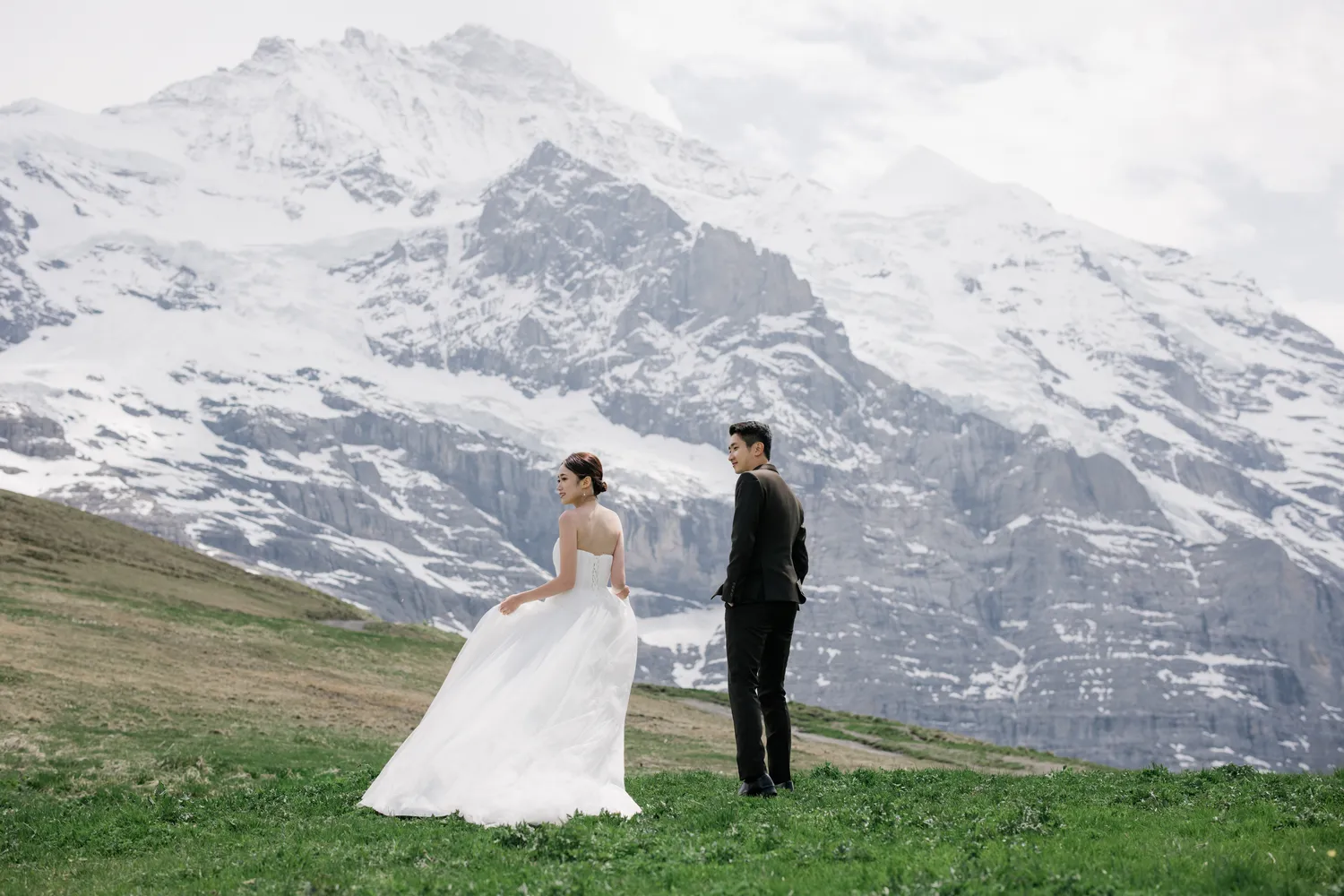 Bespoke **pre-wedding photoshoot** amidst the snowy peaks of Kleine Scheidegg in June.