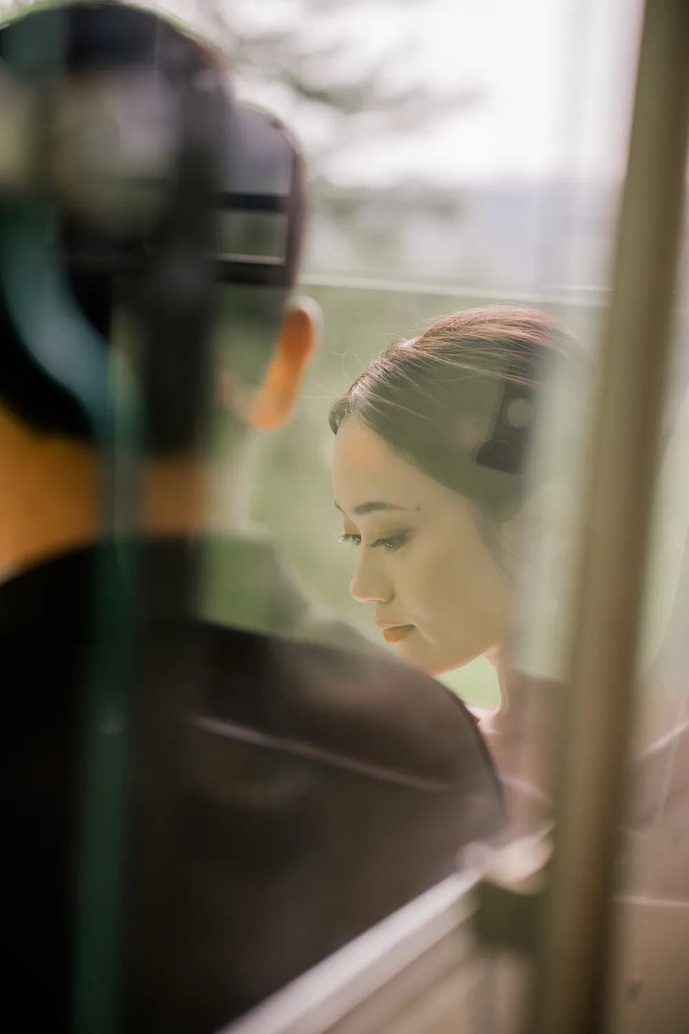 Artistic **pre-wedding portrait** through a train window reflection during a Swiss Alps photoshoot.